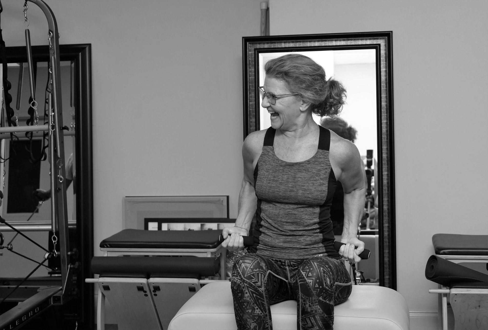 A client laughing during her session on the equipment