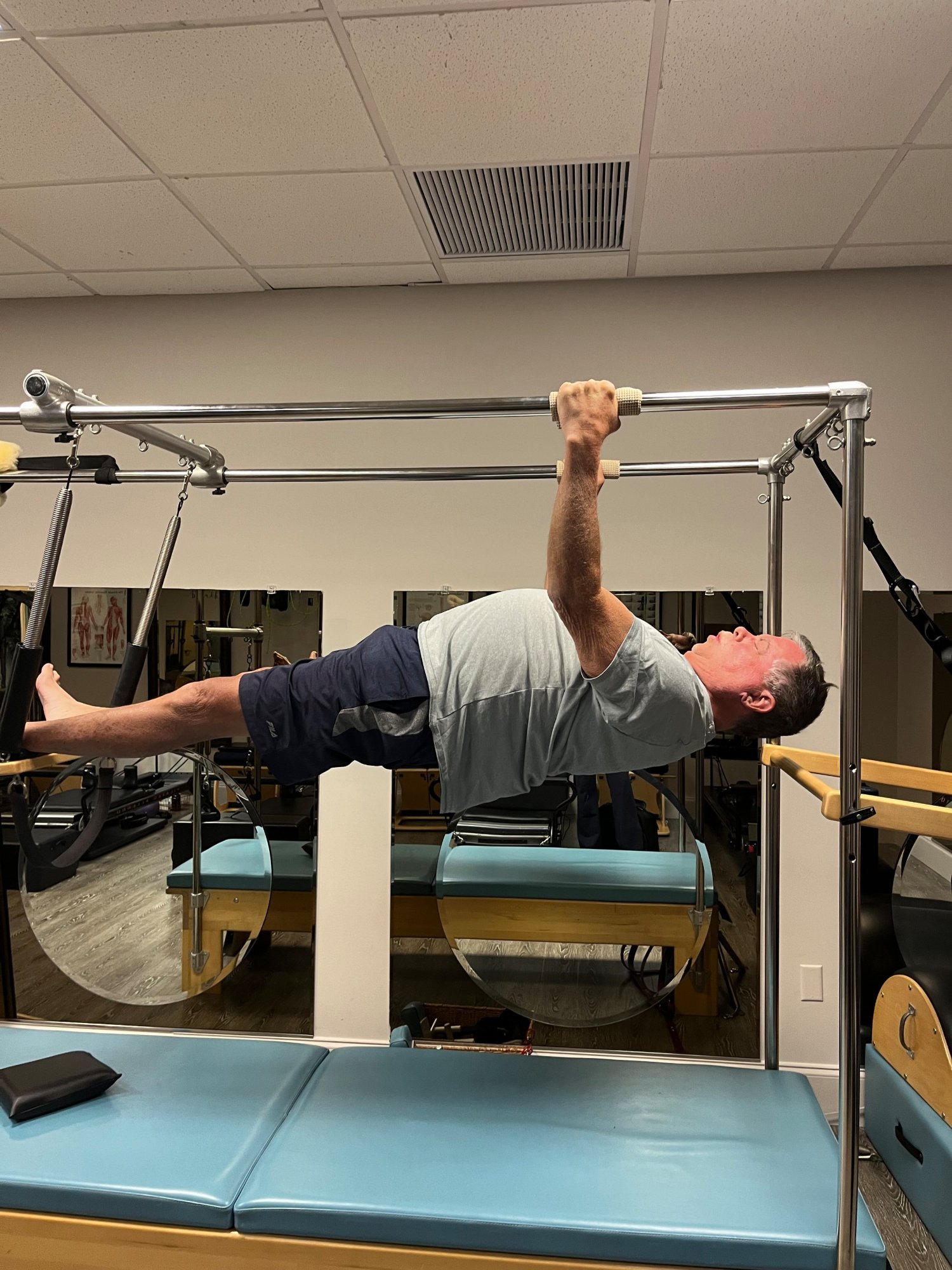 A client doing a hanging pull-up exercise on the tower